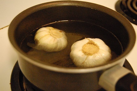 garlic cloves in simmering water